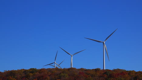 Telephoto-view-of-wind-turbines-operating-on-top-of-forested-ridge