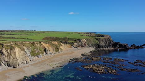 aerial-view-of-the-rocky-coastline,-beach-and-clear-water-in-the-South-of-Ireland-in-Summer-time