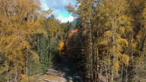 Drone-shot-of-river-,forest-and-mountains-in-autumn-,-Shot-moves-up-to-revealing-mountains,-valley-and-clouds