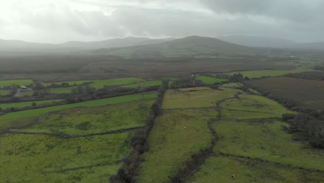 Aerial:-Typical-irish-landscape-with-green-fields,-hills-and-farmlands