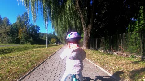 Small-Child-Riding-a-Balance-Bike---Push-Bike-in-Helmet-on-a-Sidwalk