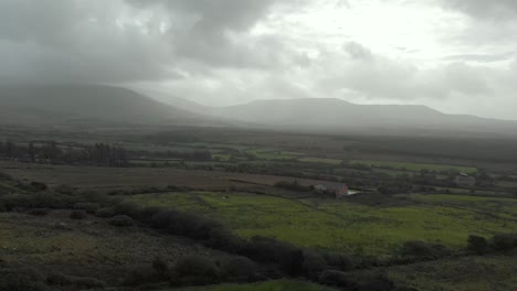 Aerial-of-moody-irish-landscape-with-hills-and-clouds-in-background