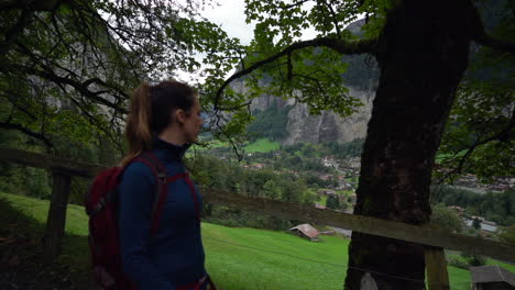 Woman-hiking-through-trees-and-shadows-on-a-gloomy-day-in-Lauterbrunnen-Valley