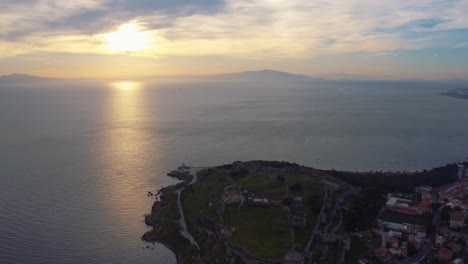Aerial-drone-Flight-over-mitilini-castle,-lesbos,-revealing-sunrise-at-sea,-lesvos,-greece