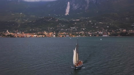 Segelschiff-Auf-Dem-Lago-Di-Garda-Mit-Garda-Klippen-Im-Hintergrund-An-Einem-Teilweise-Bewölkten-Tag