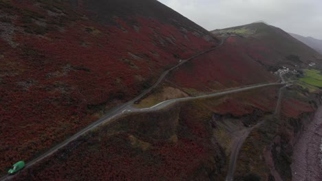 Aerial-view-of-moody-mountain-full-of-red-and-brown-plants-and-moss,-ireland