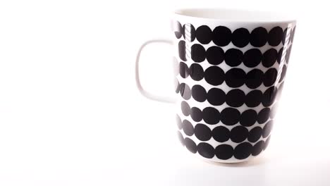 Gleitschuss-Einer-Isolierten-Kaffeetasse-Mit-Marimekko-Muster-Auf-Weißem-Hintergrund,-Elegantes-Design-Aus-Finnland