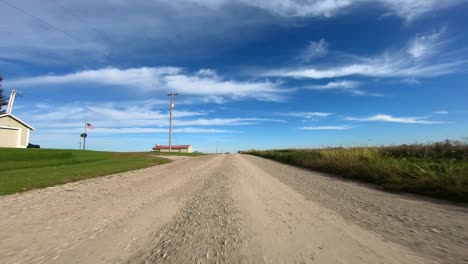 Point-of-view-footage-while-driving-down-a-gravel-road-in-rural-Iowa-as-turns-are-made-the-automobile-shadow-shifts