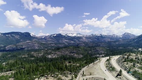 Dolly-forward-showing-highway-next-to-forest-and-revealing-more-mountains-with-ice