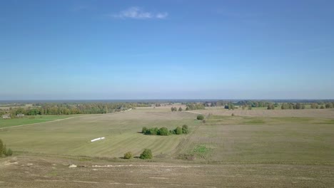 Aufsteigende-Luftaufnahme-Von-Abgeernteten-Feldern-In-Der-Landschaft-Von-Lettland