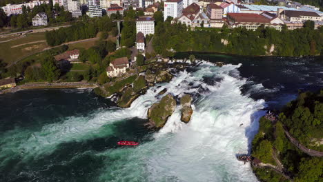 Kamerafahrt-Eines-Roten-Touristenbootes,-Das-Gegen-Den-Tosenden-Wasserfall-Rheinfall-Bei-Schaffhausen-In-Der-Schweiz-Kämpft