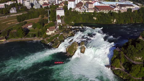 Slow-Motion:-Tracking-shot-of-a-red-tourist-boat-fighting-the-roaring-waterfall-Rheinfall-at-Schaffhausen-in-Switzerland