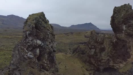 Flying-around-Londrangar,-a-pair-of-rock-pillars-on-the-coast-of-Snaefellsnes-in-Iceland