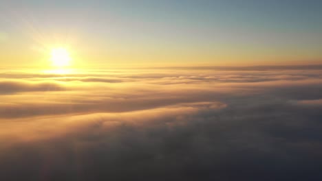 Cinematic-and-atmospheric-clip-of-sun-above-layer-of-soft-clouds-at-sunrise