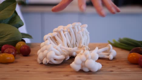 Close-up-shot-of-woman-holding-enoki-mushroom-and-when-releasing-it,-different-vegetables-around