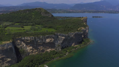 Aerial-shot-closing-in-to-the-cliffs-of-Manerba-at-Lago-Di-Garda-on-a-bright-sunny-day