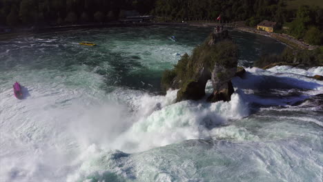 Kamerafahrt-über-Einen-Felsen-Im-Tosenden-Wasserfall-Rheinfall-Bei-Schaffhausen-In-Der-Schweiz