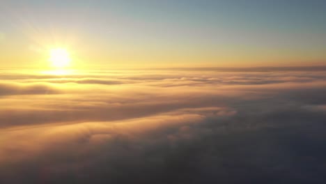 Flying-towards-sun-at-sunrise-above-clouds-like-a-bird,-drone-heavenly-panorama