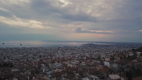 Drone-flies-above-old-town-of-Thessaloniki-on-sunset-hour-with-overcast-weather,-Greece