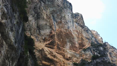 Toma-Panorámica-Vertical-Sobre-La-Dura-Y-Escarpada-Línea-Montañosa-En-Un-Día-Soleado-En-El-Lago-Di-Garda-En-Italia-Cerca-Del-Sentiero-Del-Ponale