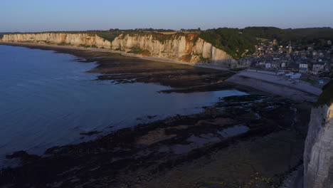 Revealing-shot-of-french-village-at-the-steep-shores-of-the-french-Normandy-atlantic-ocean-at-sunset