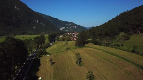 Drone-shot-of-a-road-surrounded-by-fields,-near-Kobarid,-Slovenia