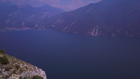 Aerial-reveal-shot-of-a-trail-in-the-cliffs-above-Lago-di-Garda-in-Italy
