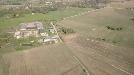 Luftaufnahme-Des-Ländlichen-Dorfes-Mit-Kleinem-Sägewerk-Und-Schmalen-Feldwegen