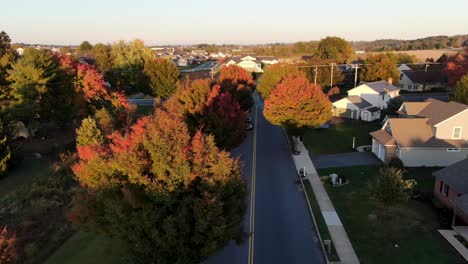Aerial-Dolly-Shot-Während-Des-Sonnenuntergangs-In-Pennsylvania-Herbst,-Bunte-Blätter,-Straße,-Häuser,-Gemeindezentrum-In-Der-Nähe