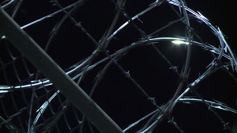 CLOSE-UP-BARB-WIRE-FENCE-AT-NIGHT