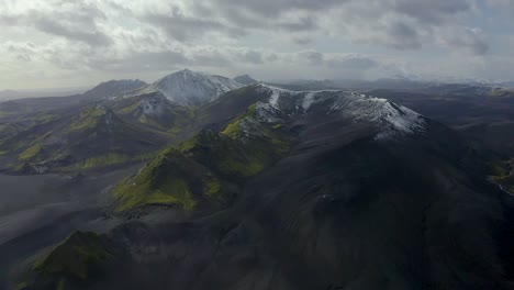 A-drone-video-from-the-Highlands-of-South-Iceland-showing-black-sands,-green-moss-and-snow-in-the-mountains