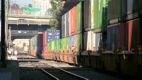 TRAIN-MOVING-SLOWLY-IN-BETWEEN-BUILDING-IN-CITY