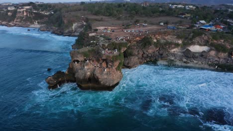 Antena-Crepuscular-Orbita-Alrededor-De-Un-Acantilado-Rocoso-Sobre-El-Océano-índico-En-La-Isla-De-Bali,-Indonesia