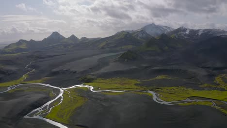 A-slow-motion-drone-video-from-the-Highlands-of-South-Iceland-showing-black-sands,-green-moss-and-snow-in-the-mountains
