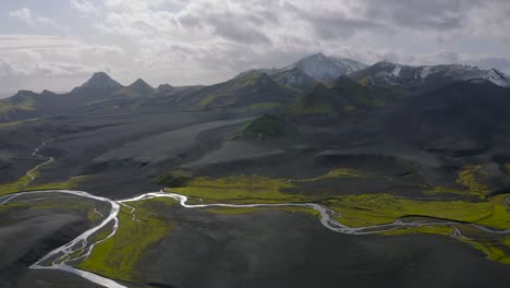 Un-Video-De-Drones-De-Las-Tierras-Altas-Del-Sur-De-Islandia-Que-Muestra-Arenas-Negras,-Musgo-Verde-Y-Nieve-En-Las-Montañas