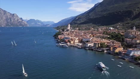 Aerial-shot-moving-towards-Malcesine-at-the-Lago-di-Garda-on-a-bright-sunny-summer-day