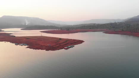 Lonavla-lake-drone-wide-shot-few-boats-standing-at-a-small-island-in-sunset
