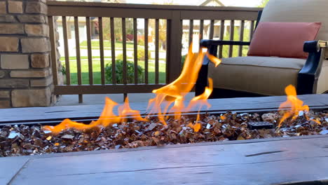 Slow-motion-video-of-a-fire-pit-with-flames-and-a-chair-on-a-front-porch