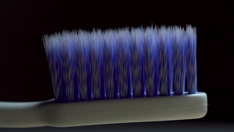 Light-sweep-across-blue-new-toothbrush-isolated-macro