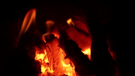 A-steady-slow-motion-shot-of-a-hot-fire-burning-and-embers-glow-orange