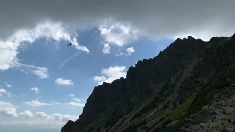 Mountain-Rescue-Helicopter-Flying-Over-High-Tatra-Summit-on-Sunny-Cloudy-Day