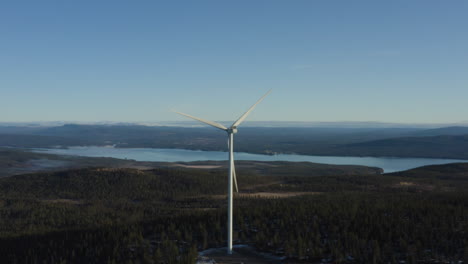Wind-Energy-Harvesting-By-The-Windmills-Of-Osen,-Norway-With-A-Lake-And-Hills-In-The-Background---Aerial-Shot