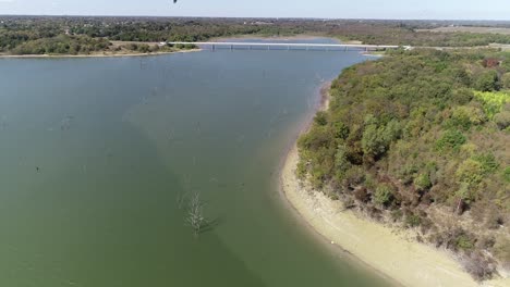 Aerial-video-of-Lake-Lavon-on-the-North-West-side-with-trees-underneath-and-shore-to-the-right