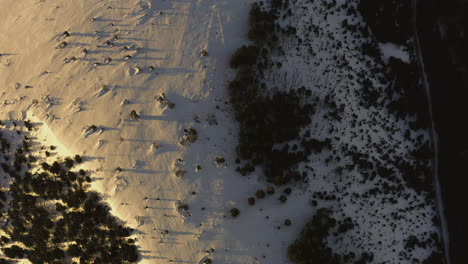 Birdseye-Luftaufnahme-Eines-Schneebedeckten-Plateaus,-Das-Eine-Windkraftanlage-Enthüllt