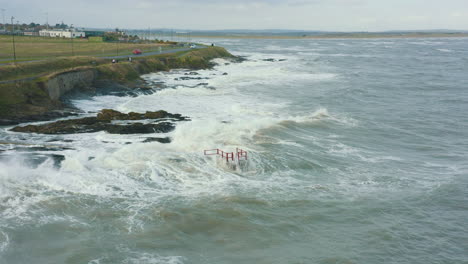 Aerial-view-of-waves-crashing-against-rocks-along-the-coastline