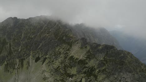Massive-Clouds-Cover-the-Mountain-Range-Near-at-Skok-Waterfall-and-the-High-Tatras-in-Slovakia---Aerial-shot