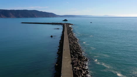 Aerial-flyover,-jetty-into-the-Pacific-Ocean-in-sunny-Northern-California
