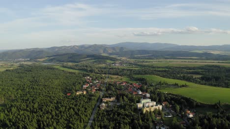 Peaceful-View-of-Villages-During-Golden-Hour-Over-High-Tatry-Forest-in-Slovakia---Aerial-shot