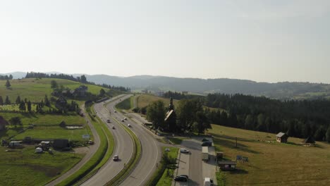 Luftaufnahme-Der-Autobahn-Und-Der-Kirche-Zwischen-Tatra-berg-Mit-Bewölktem-Blauem-Himmel-Oben-In-Der-Slowakei