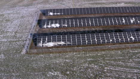 Luftdrohnenansicht-Einer-Leicht-Schneebedeckten-Solarmodulstation,-Die-Eine-Farm-Mit-Strom-Versorgt